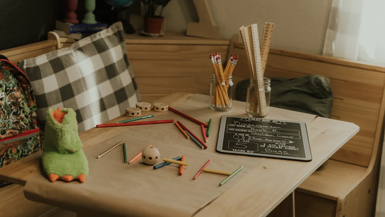 Schreibwaren, Stifte und ein Buch auf einem Schreibtisch vorbereitet für den ersten Schultag.