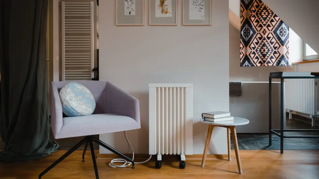 Moderner elektrischer Heizkörper in einem Wohnraum vor einer rustikalen Ziegelwand positioniert.