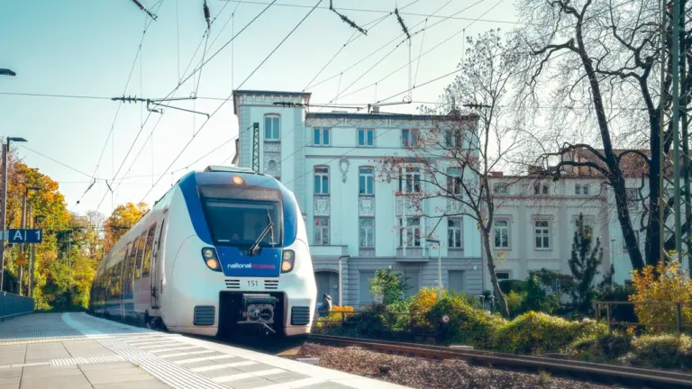 Ein blau-weißer Zug fährt in den Bahnhof von Bonn in Deutschland ein.
