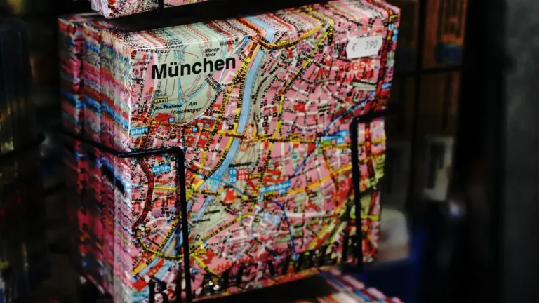 Ein Stadtplan von München auf einem schwarzen Ausstellungsständer, Fokus auf den Stadtnamen.