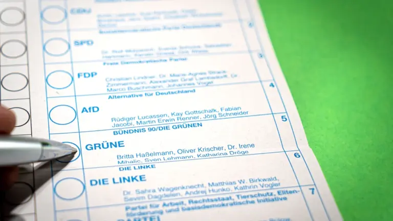 Ein Stimmzettel für eine deutsche Wahl, auf dem jemand ein Kreuz setzt.