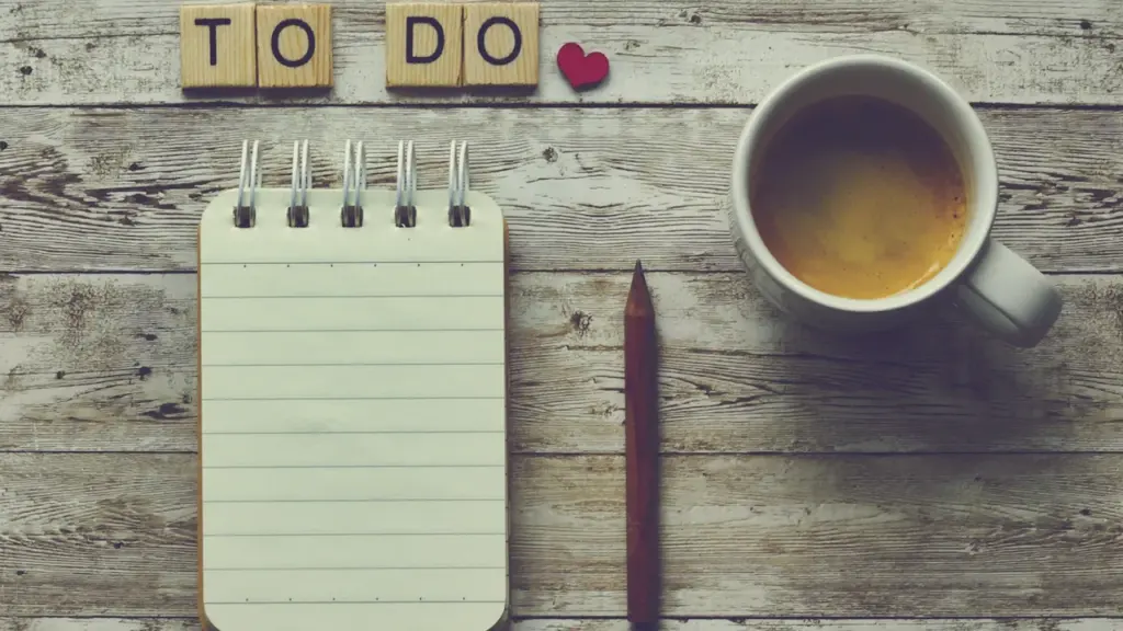 Notizbuch mit der Aufschrift To-Do und eine Tasse Kaffee auf einem Holztisch.