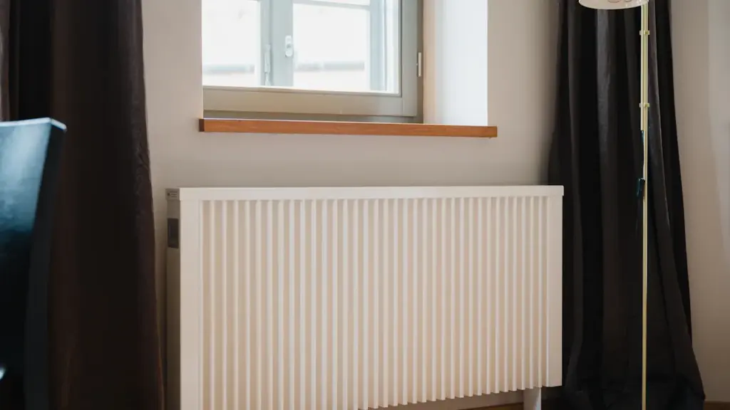 Ein moderner Heizkörper vor einem Fenster in einer privaten Wohnumgebung im Herbst.